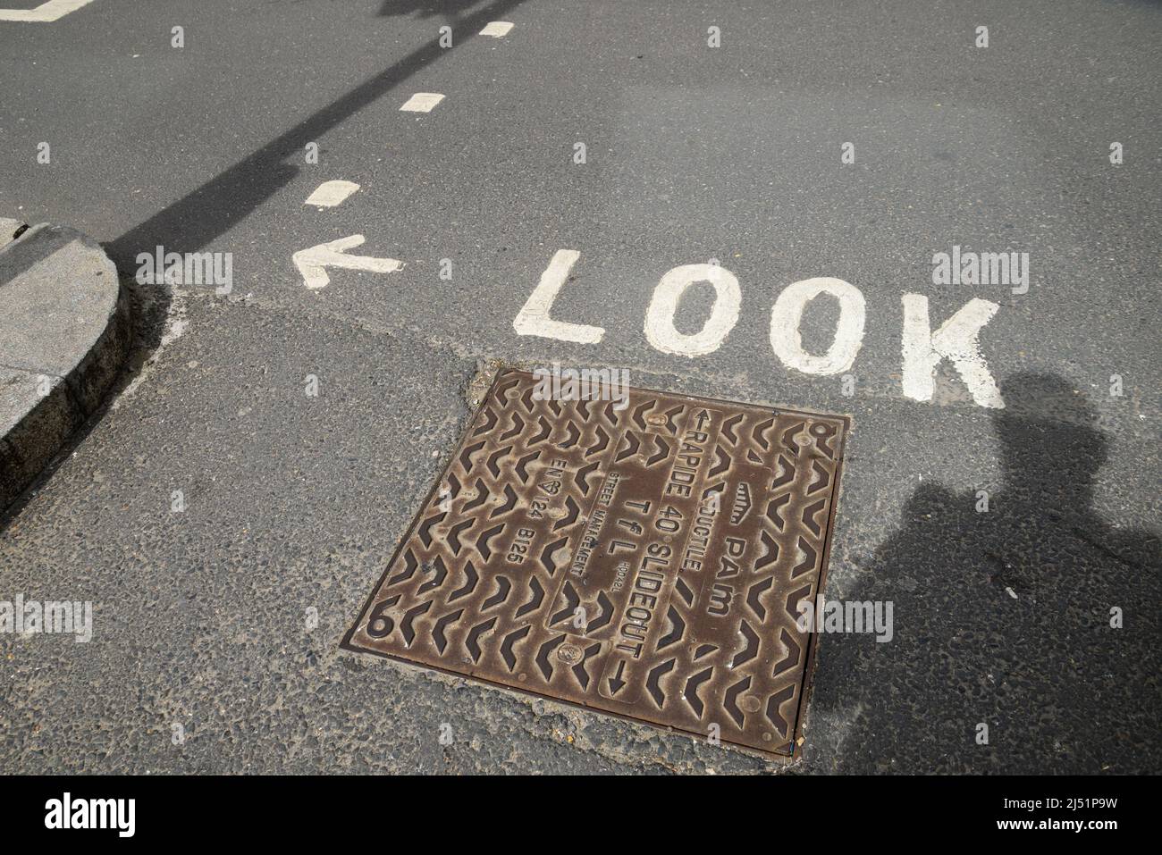 Guardate a sinistra su una strada che attraversa la zona d'ombra e i servizi di botola d'uomo, Regno Unito Foto Stock