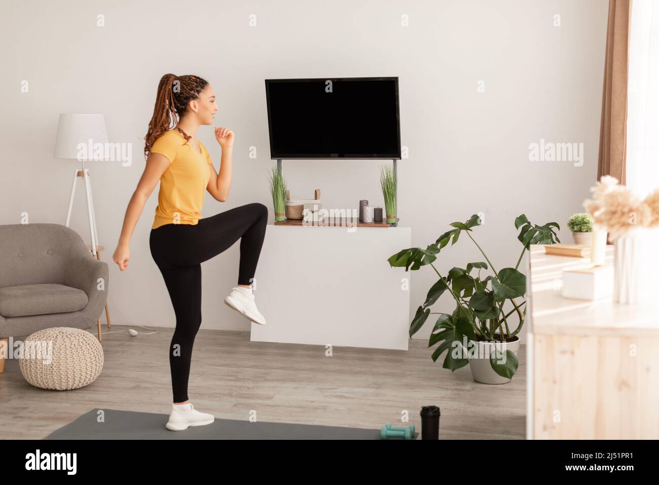 African American Lady fare ginocchio a gomito gamba esercizio interno Foto Stock