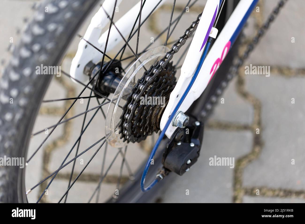 Una bicicletta bianca per bambini, un primo piano del deragliatore e una ruota libera della ruota posteriore. Sfondo sfocato, foto scattata in luce naturale e soffusa Foto Stock