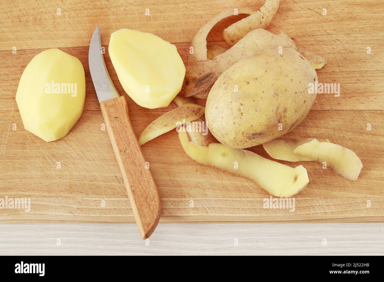 Peeling patate in una cucina casalinga. Tempo di cottura Foto Stock