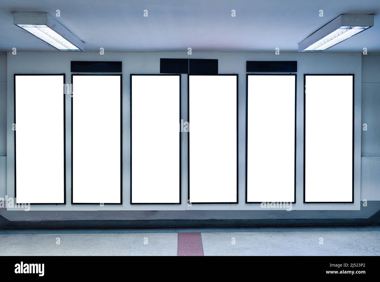 Fila di cartelloni digitali verticali vuoti sul muro della metropolitana Foto Stock