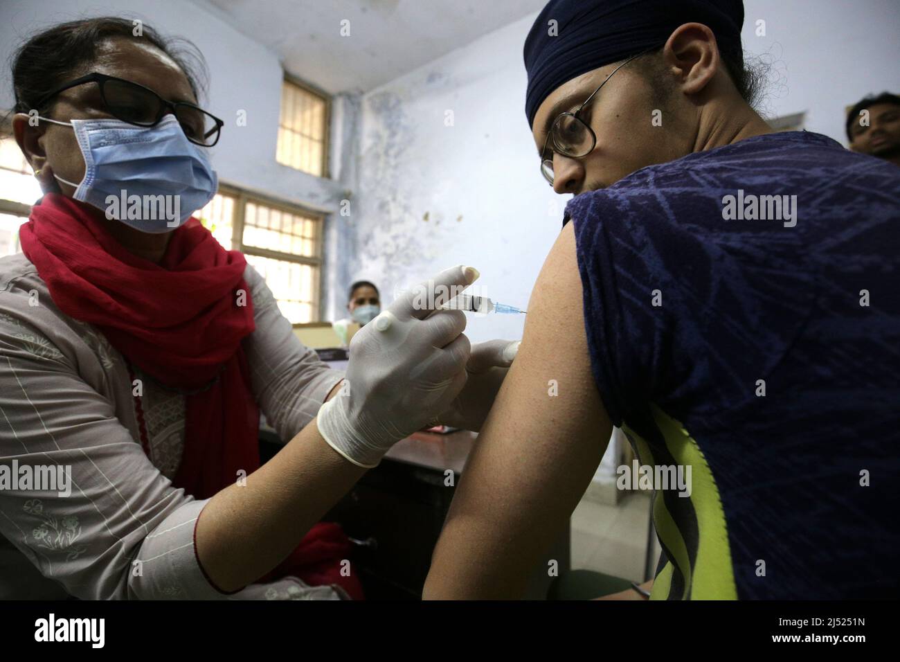Punjab, India. 19th Apr 2022. Un operatore sanitario inocula una dose di vaccino COVID-19 ad un uomo in un centro sanitario governativo nel distretto di Amritsar, nello stato del Punjab, India, 19 aprile 2022. Il COVID-19 dell'India è aumentato a 43.045.527 il martedì, con 1.247 nuovi casi registrati durante le ultime 24 ore attraverso il paese, ha mostrato i dati più recenti del ministero della salute. Inoltre, una morte dovuta alla pandemia da lunedì mattina ha portato il bilancio totale delle vittime a 521.966. Credit: Str/Xinhua/Alamy Live News Foto Stock