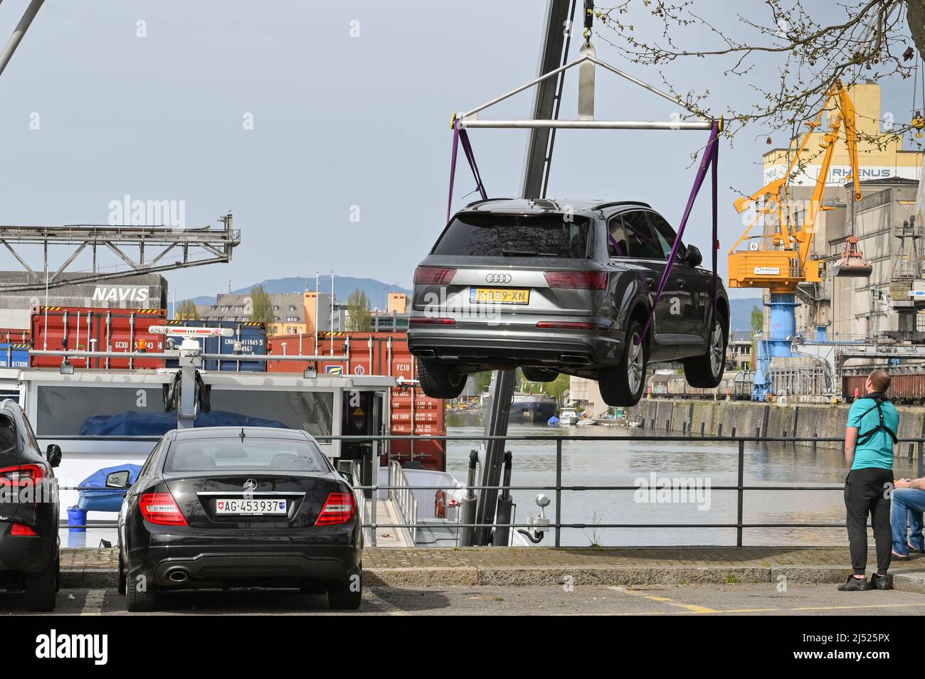 Basilea, Svizzera - Aprile 2022: L'auto Audi viene scaricata da una gru da una chiatta industriale nelle banchine della città sul fiume Reno Foto Stock