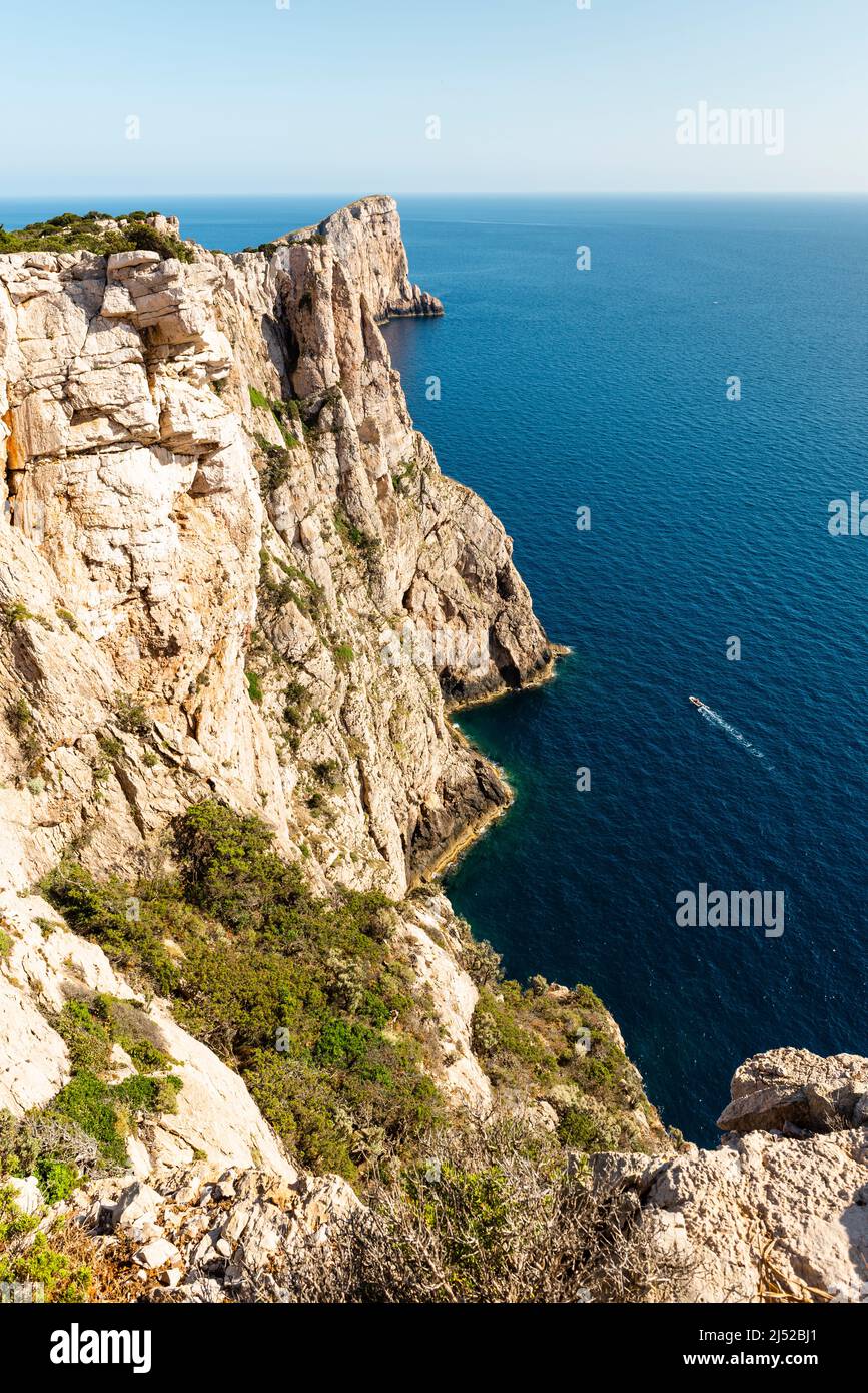 Bella natura e attività ricreative in Sardegna - crociere in motoscafo nel mare azzurro sotto le ripide scogliere della costa di Capo Caccia Foto Stock