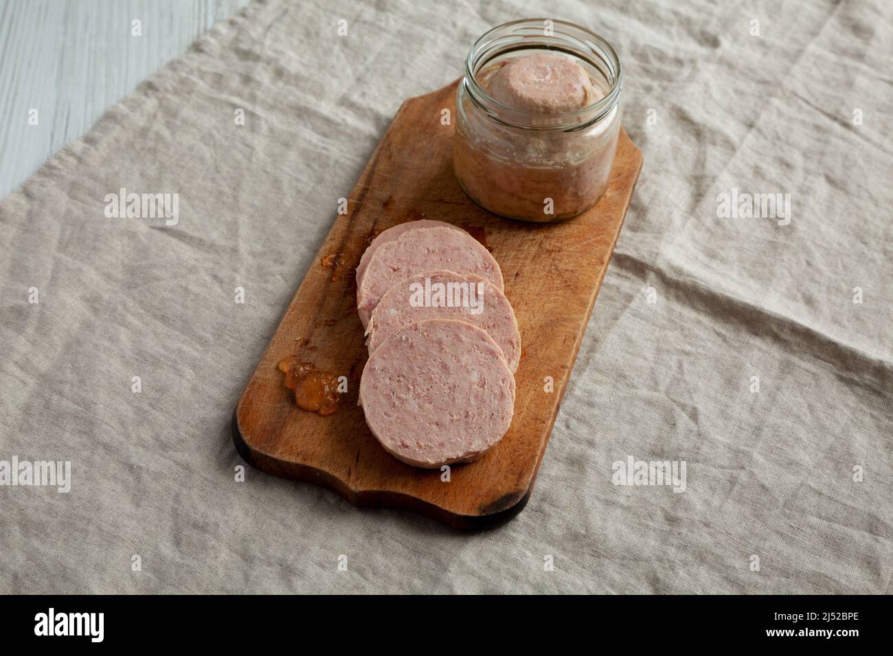 Jagdwurst fatto in casa su un rustico asse di legno, vista laterale. Foto Stock