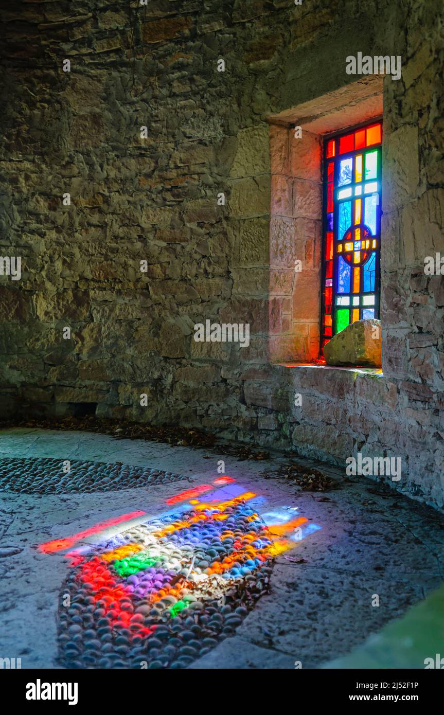 I colori di una vetrata sul pavimento in pietra di una chiesa Foto Stock