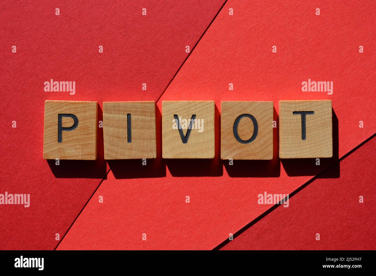 Pivot, parola in lettere di legno lettera isolata su sfondo rosso Foto Stock