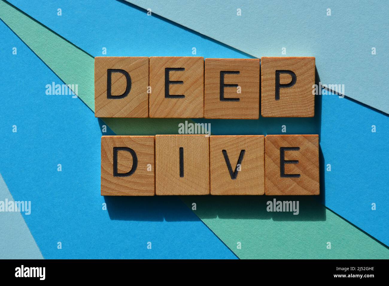 Deep Dive, parole in lettere di legno alfabeto isolato su sfondo blu Foto Stock