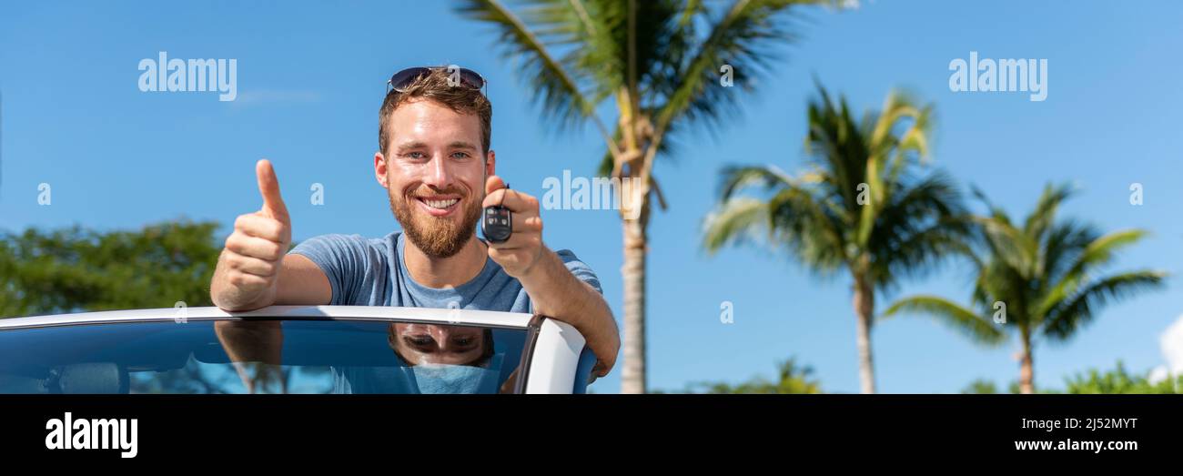 Chiave auto nuovo giovane proprietario conducente uomo mostrando le chiavi e pollici in su felice per acquistare o vendere nuove automobili usate convertibili. Concetto di patente di guida con guida Foto Stock