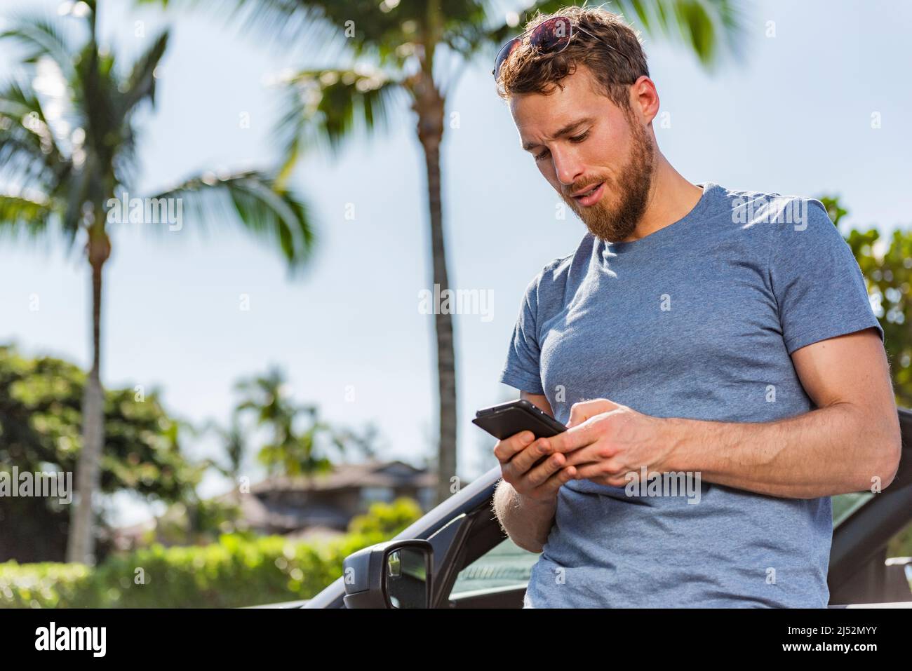 Operatore di telefonia auto che utilizza l'app per smartphone per il carsharing o il noleggio di vacanze di viaggio su nuovi sport convertibili. Problema di incidente durante le vacanze estive Foto Stock