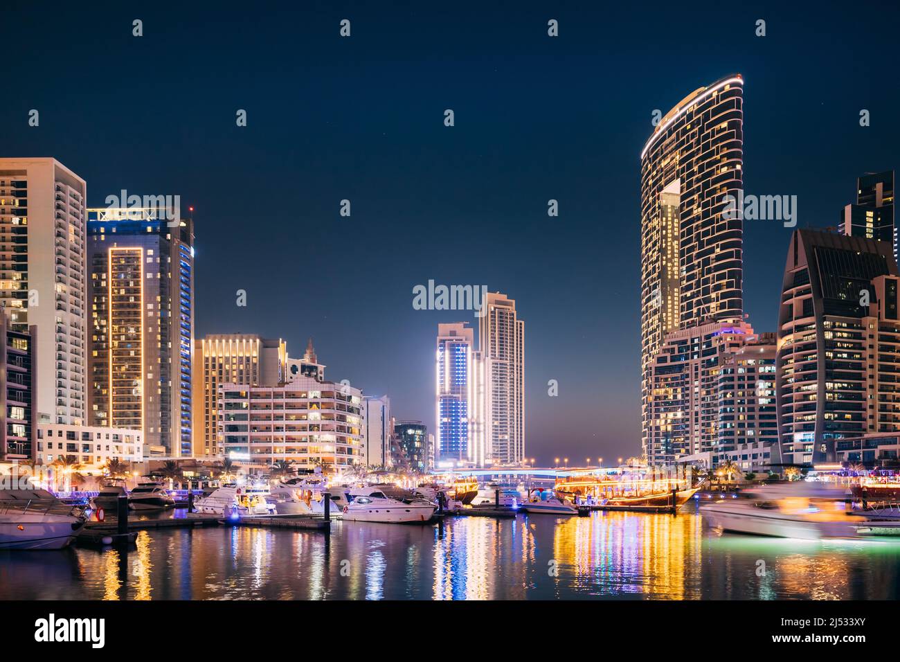 Splendida vista notturna dello skyline di Dubai Marina. Barche ormeggiate vicino al Molo della Città, Jetty nelle luci notturne Foto Stock