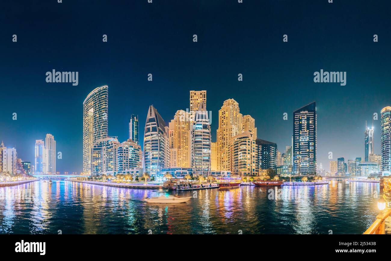 Splendida vista notturna di alti edifici del quartiere residenziale a Dubai Marina e Tourist Boat, Barca turistica vela a Dubai Marina Foto Stock