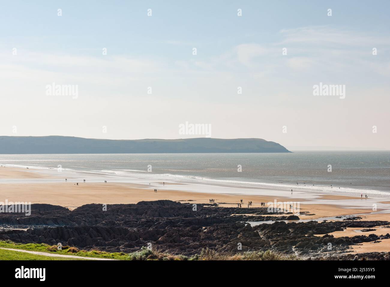 Spiaggia di sabbia a bassa marea con la gente che si gode il sole e il mare Foto Stock