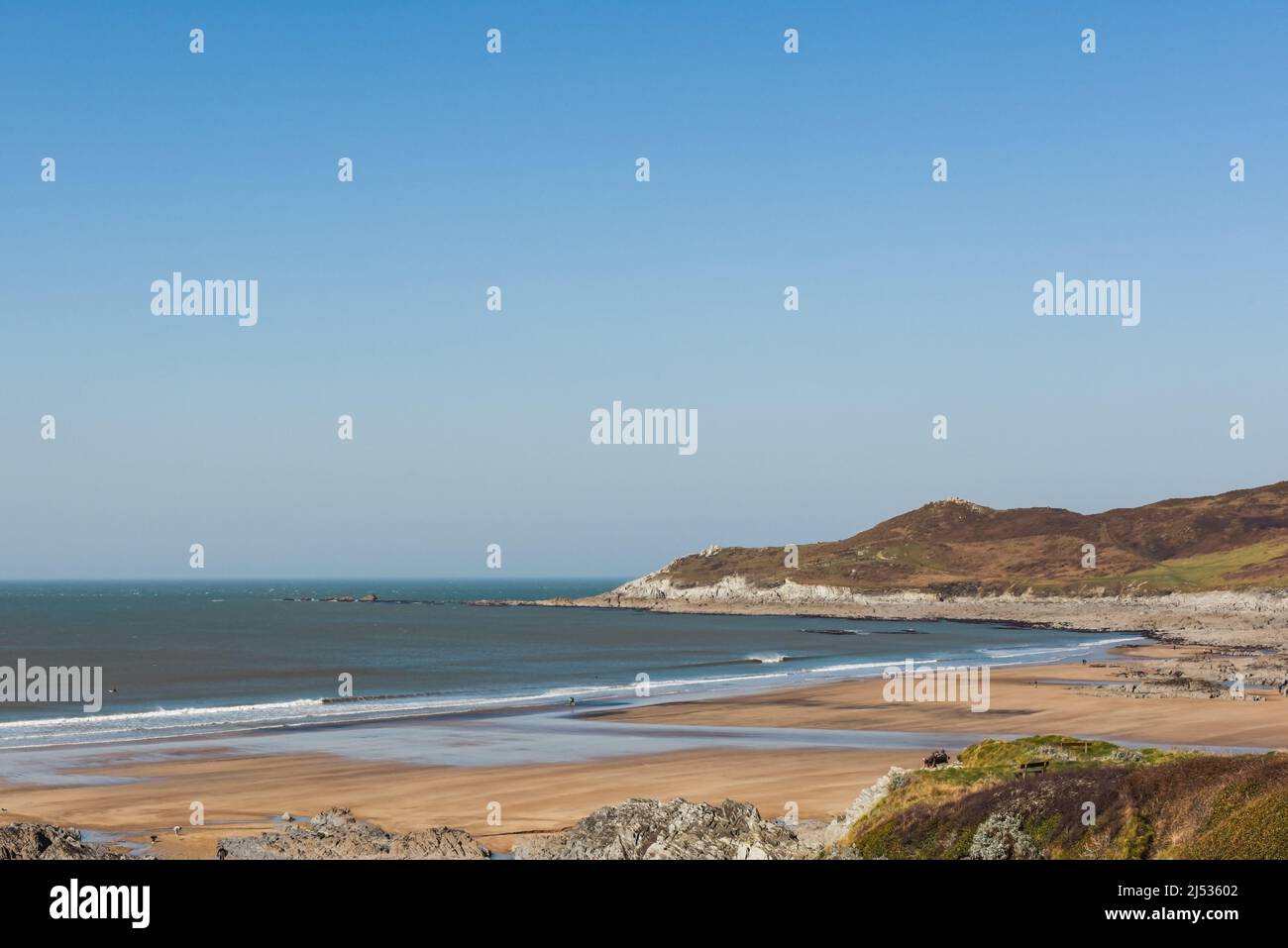 Spiaggia di sabbia a bassa marea con la gente che si gode il sole e il mare Foto Stock