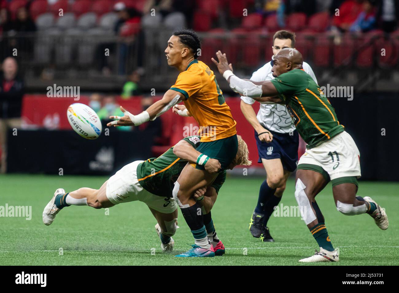 Vancouver, Canada, 16 aprile 2022: Dietrich Roache (al centro) del Team Australia 7s passa la palla mentre viene affrontato da JC Pretorius (a sinistra) del Team Sud Africa 7s durante la partita contro il Team Sud Africa 7s il giorno 1 della HSBC Canada Sevens al BC Place a Vancouver, Canada. Il Sudafrica ha vinto con il punteggio 22-19. Foto Stock