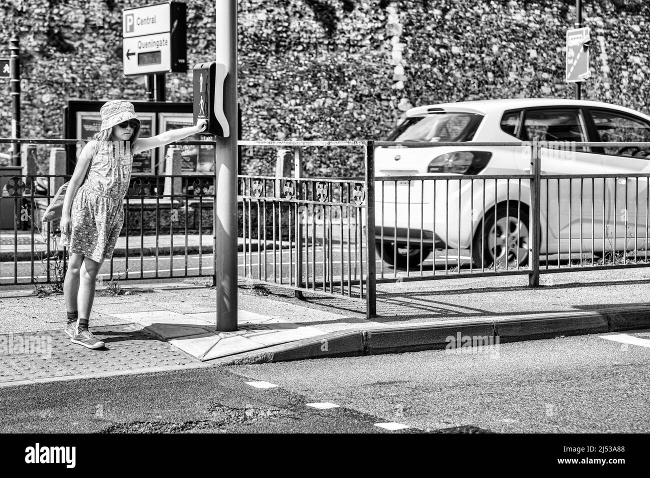 Una giovane ragazza in attesa di un passaggio pedonale a Canterbury, Inghilterra. Foto Stock