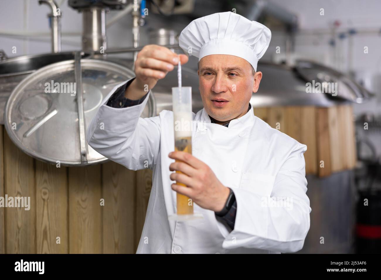 Ritratto di esperto che controlla la birra nel laboratorio di Brew-house. Foto Stock