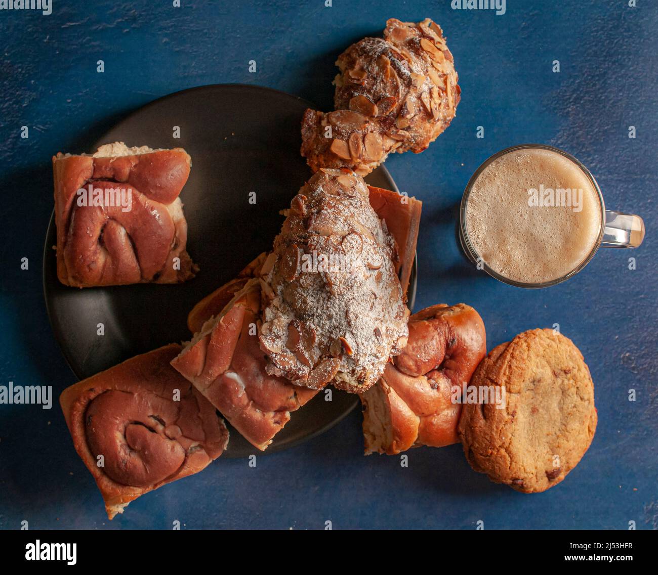 Pane dolce o rotoli con uvetta con acup di moka sul lato, su un tavolo di legno orizzontale ltop vista piatto laici scuro cibo fotografia Foto Stock