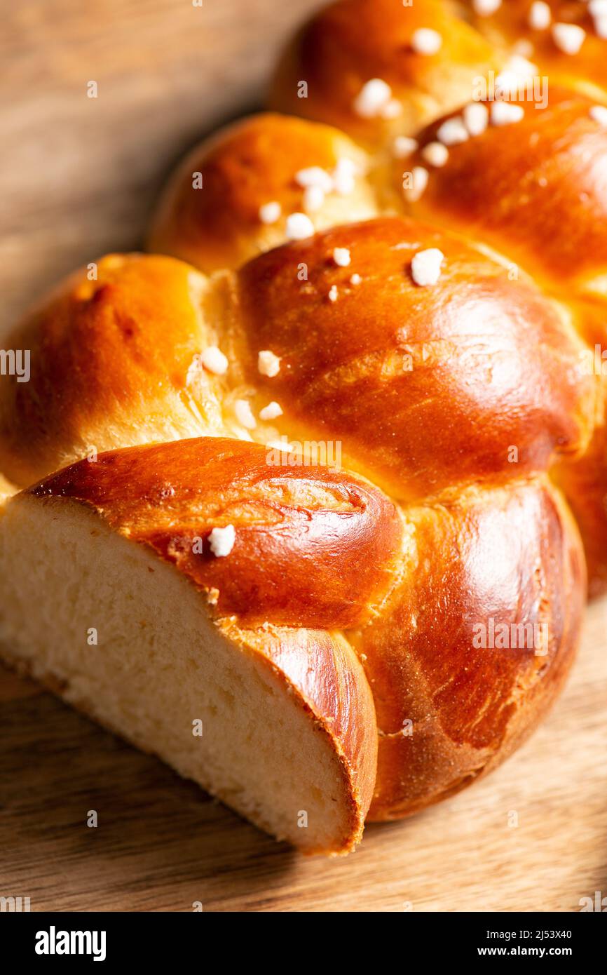 Bel pane dorato cotto a tre treccia con uova lavate e zucchero di grandine. Challah è un pane speciale di origine ebraica Ashkenazi, solitamente intrecciato e typi Foto Stock