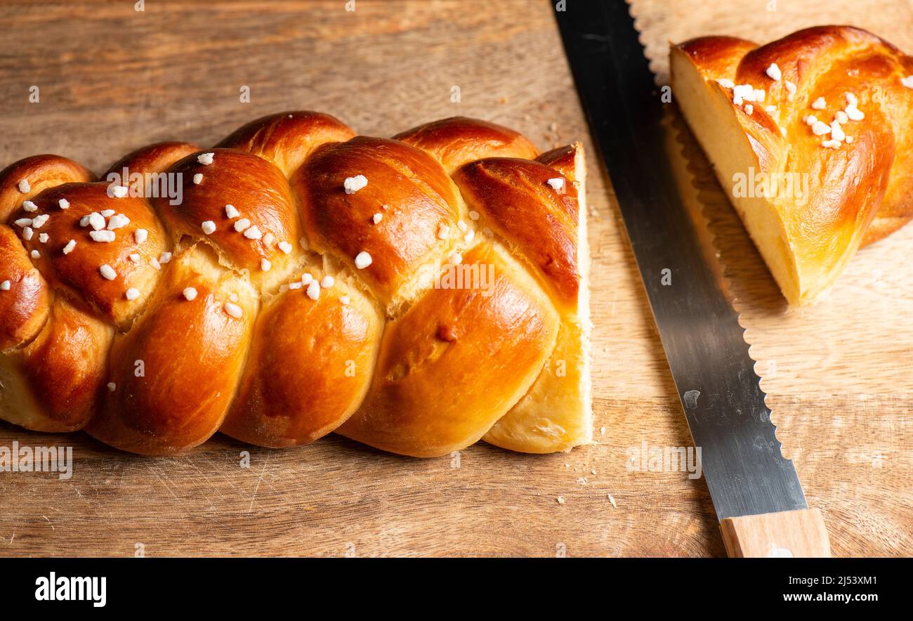 Bel pane dorato cotto a tre treccia con uova lavate e zucchero di grandine. Challah è un pane speciale di origine ebraica Ashkenazi, solitamente intrecciato e typi Foto Stock