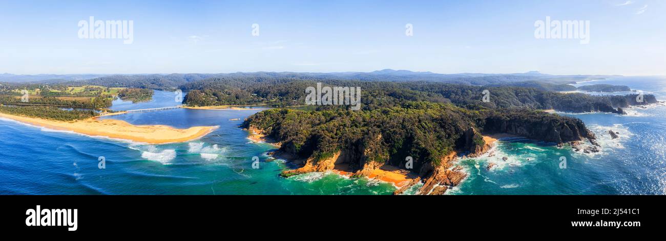 Panoramica costa Sapphire dell'Australia sul Pacifico in un ampio panorama aereo del fiume Bega che entra nell'oceano vicino alla spiaggia di Tathra. Foto Stock