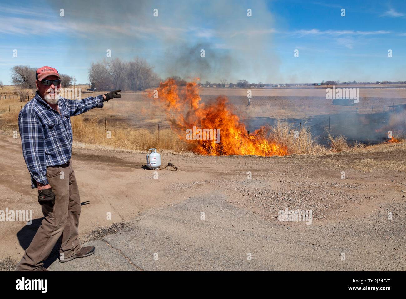 Pueblo, Colorado - Un coltivatore brucia stoppie e erbacce dal suo campo in preparazione per piantare un nuovo raccolto. Foto Stock