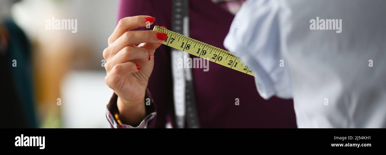 Donna fashion designer effettua misurazioni con centimetri Foto Stock