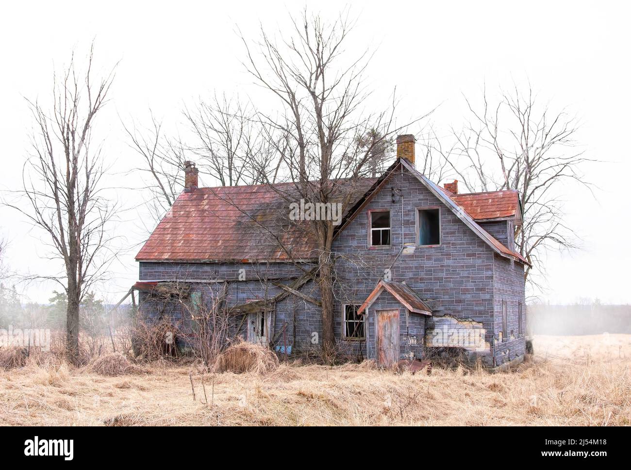 Un casale dall'aspetto spaoky abbandonato si trova tranquillamente in un prato di campagna nella zona rurale di Ottawa, Canada Foto Stock