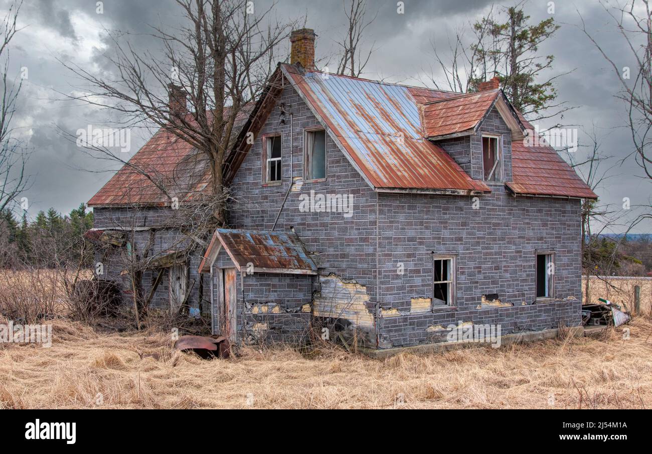 Un casale dall'aspetto spaoky abbandonato si trova tranquillamente in un prato di campagna nella zona rurale di Ottawa, Canada Foto Stock