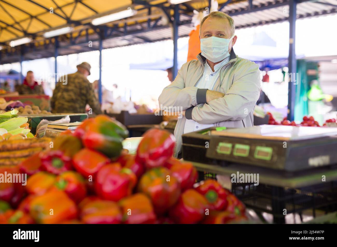 Uomo in maschera di faccia acquistare pepe in gregrocery Foto Stock