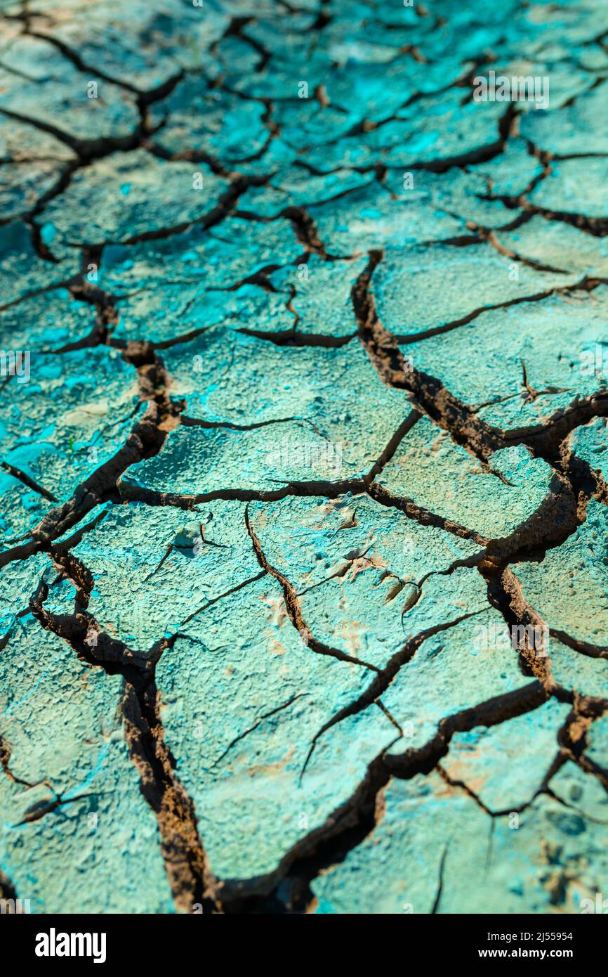 Liquido chimico blu essiccato su terreno secco incrinato, danni ambientali e inquinamento, fuoco selettivo Foto Stock