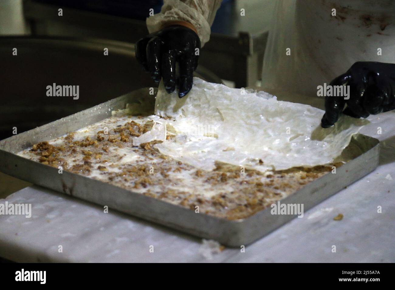 Ankara, Turchia. 19th Apr 2022. Il 19 aprile 2022 un pasticcere produce Gullach, un dessert turco, presso una panetteria ad Ankara, Turchia. Gullach, un dessert turco a base di latte e melograno e tradizionalmente servito durante il mese santo musulmano del Ramadan, offre un dolce e leggero finale al pasto veloce. Credit: Mustafa Kaya/Xinhua/Alamy Live News Foto Stock