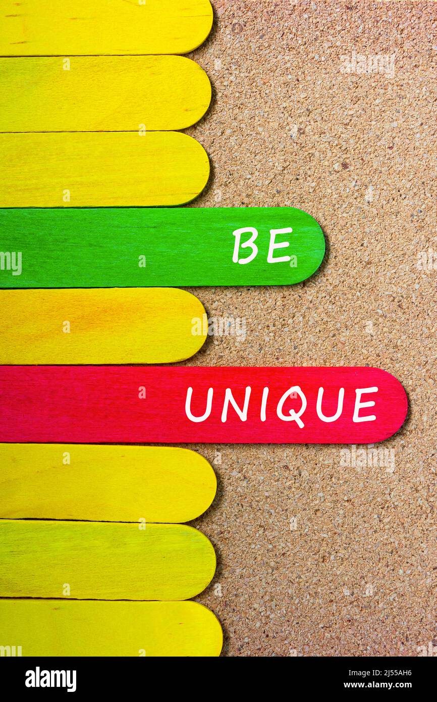 Citazione motivazionale e ispiratrice sul bastone colorato di legno - sia unico. Foto Stock