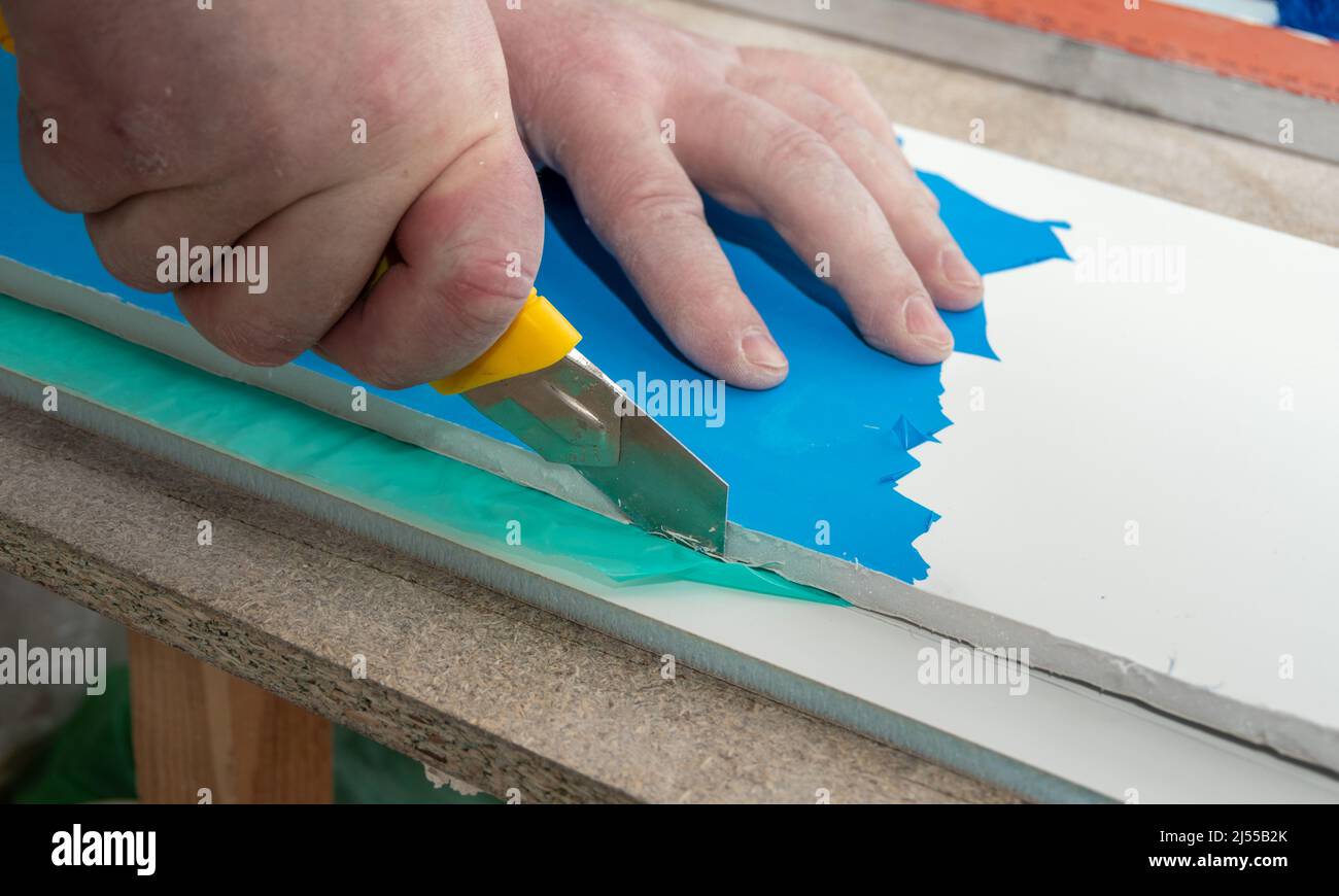 Misurazione del linoleum su un taglio. L'uomo taglia il linoleum. Metro a  nastro e mano di un uomo con un pezzo di pavimento Foto stock - Alamy