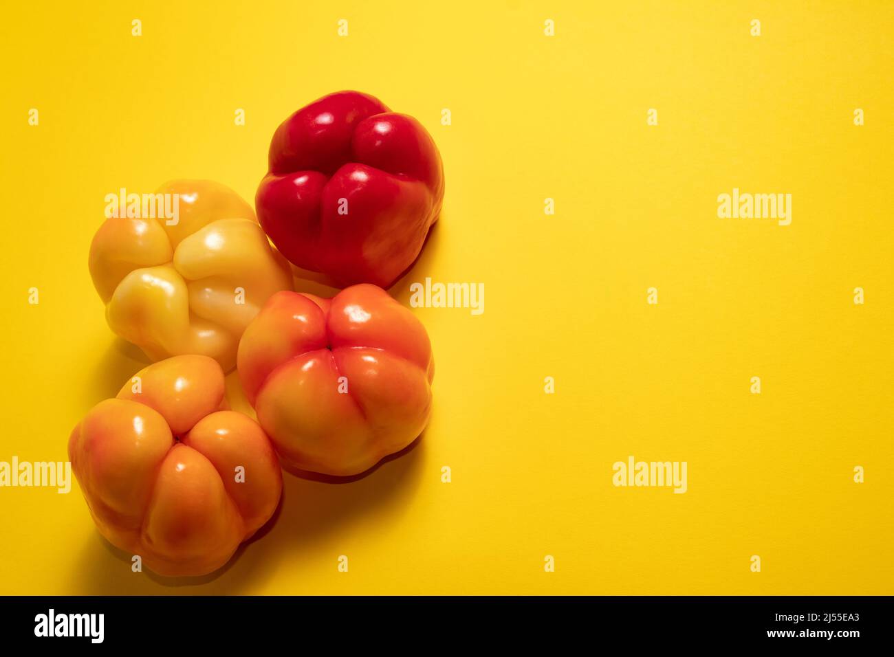Peperoni colorati su sfondo giallo Foto Stock