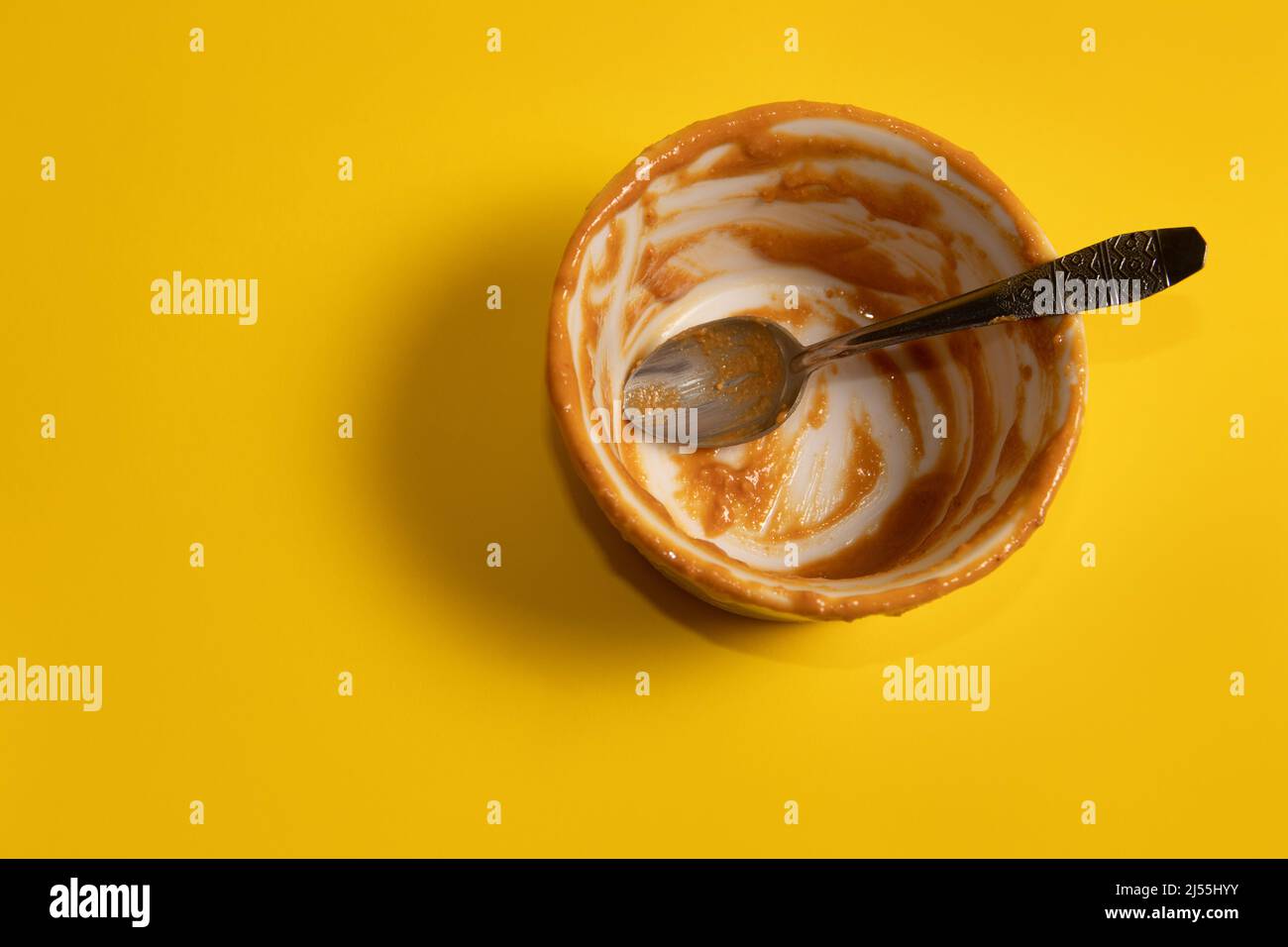 Una tazza vuota di burro di arachidi con un cucchiaio Foto Stock