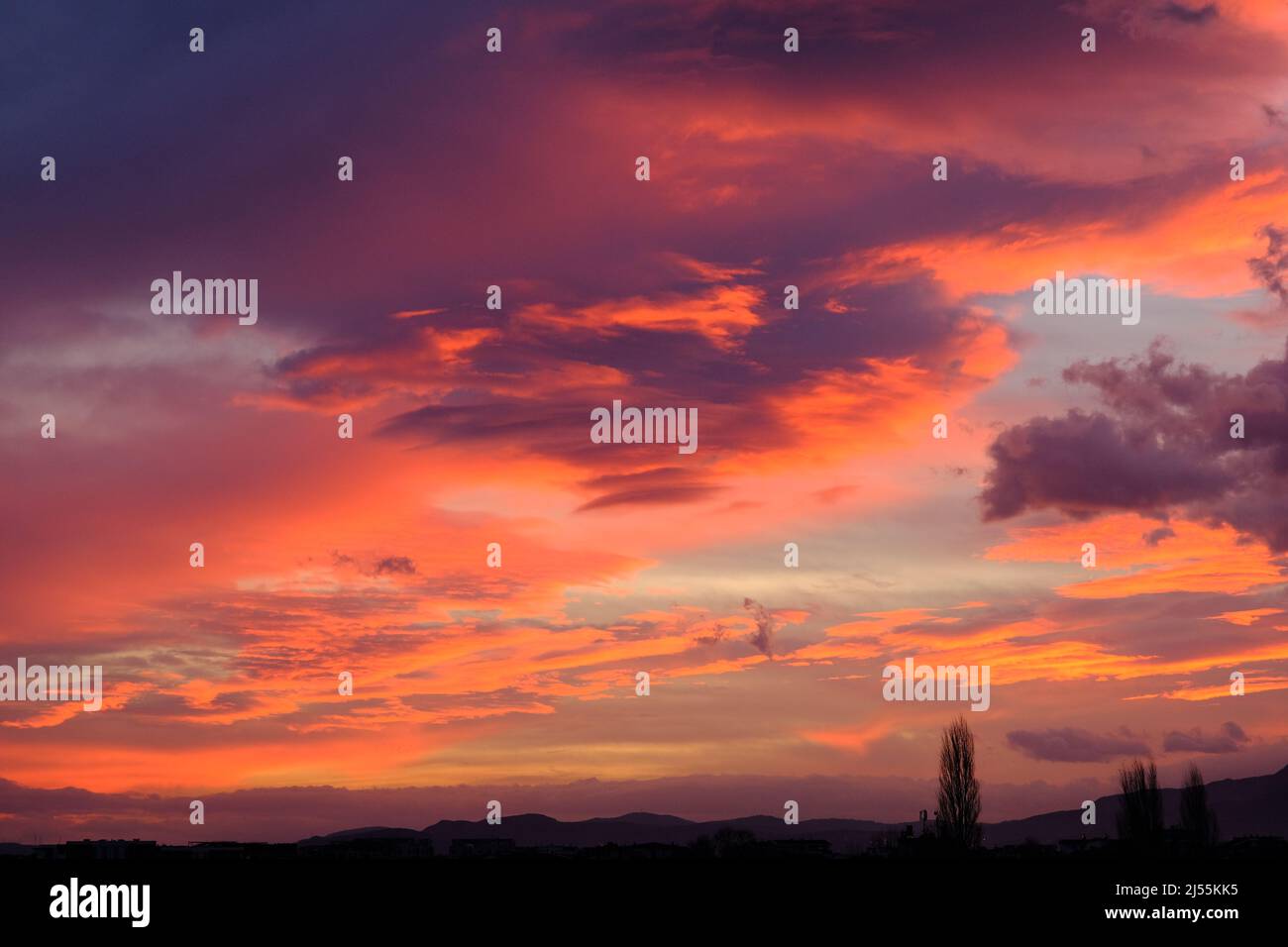 Idea di concetto del tramonto. Sole riflessione sulle nuvole rosse di mattina presto. Foto Stock