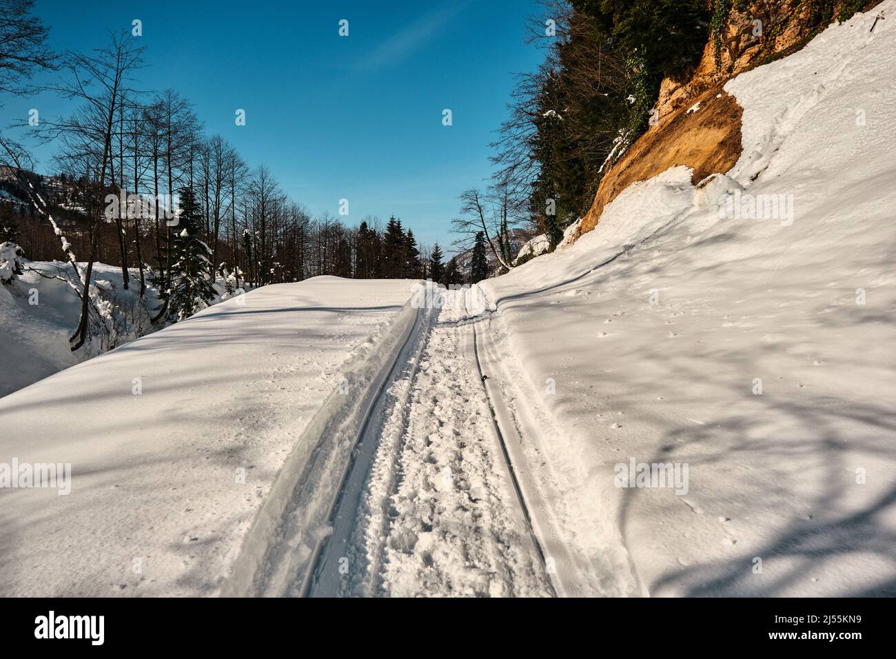 Idea di concetto di inverno. Neve e strada ghiacciata in cima alla montagna. Foto Stock