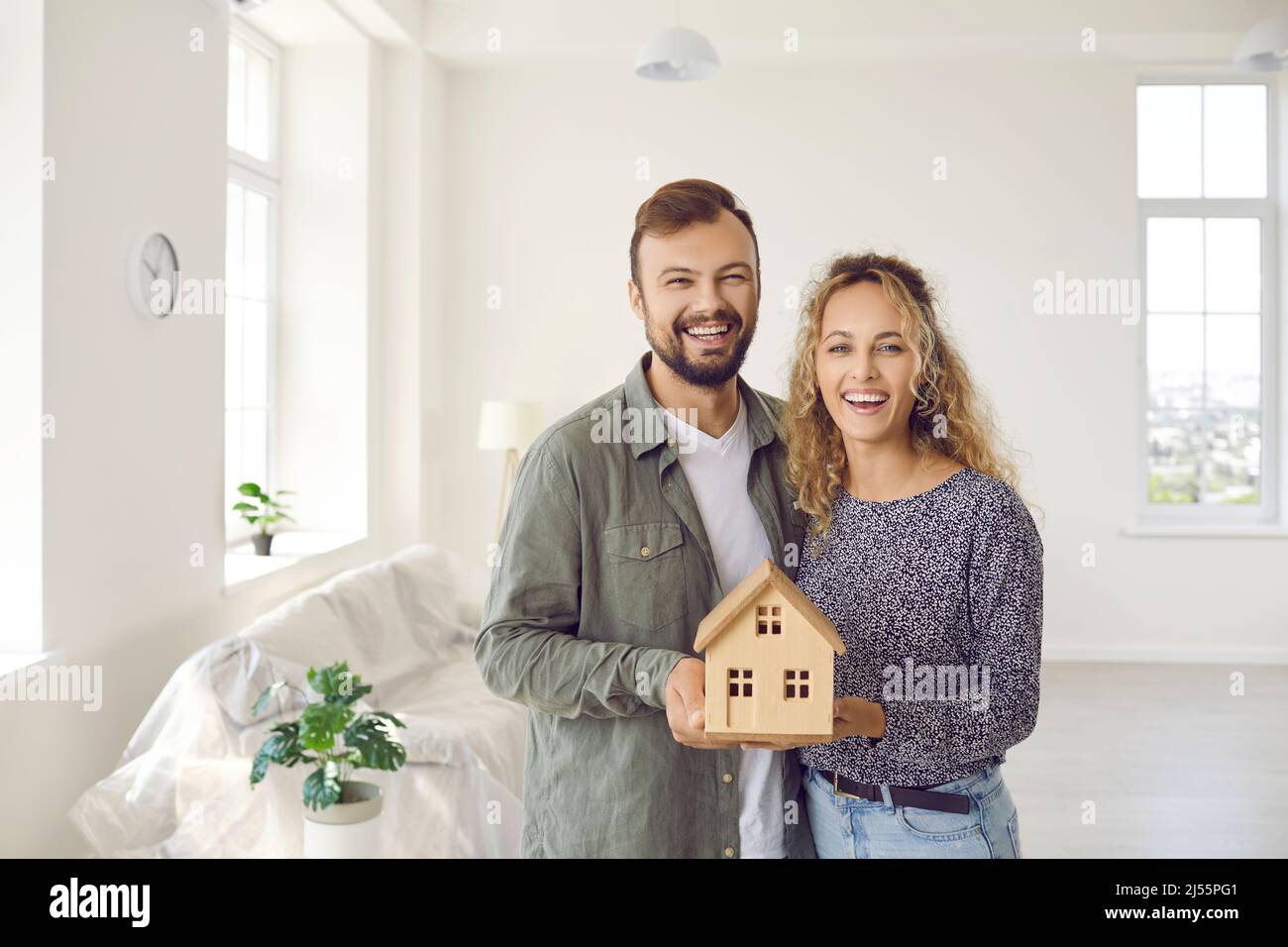 Ritratto dei proprietari di coppia celebrare il trasferimento in nuova casa Foto Stock