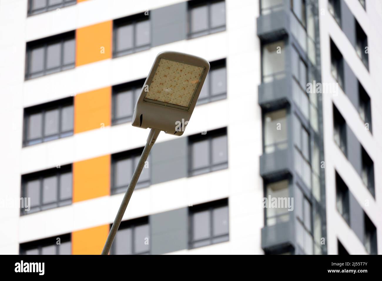 Lampione a LED su un alto sfondo dell'edificio. Luci a LED moderne in città, risparmio di energia elettrica Foto Stock