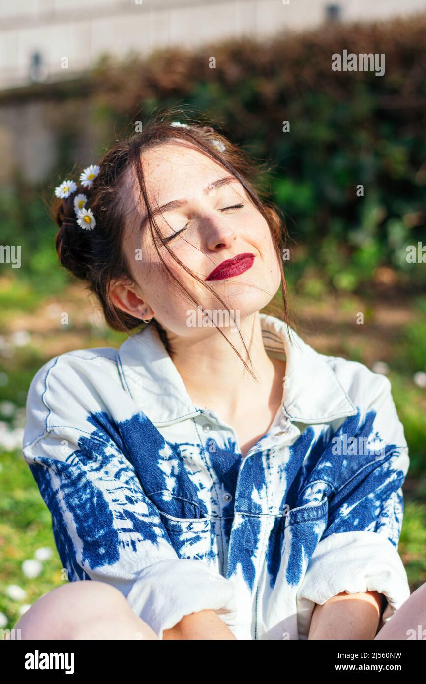 donna con fiori nei capelli all'aperto Foto Stock