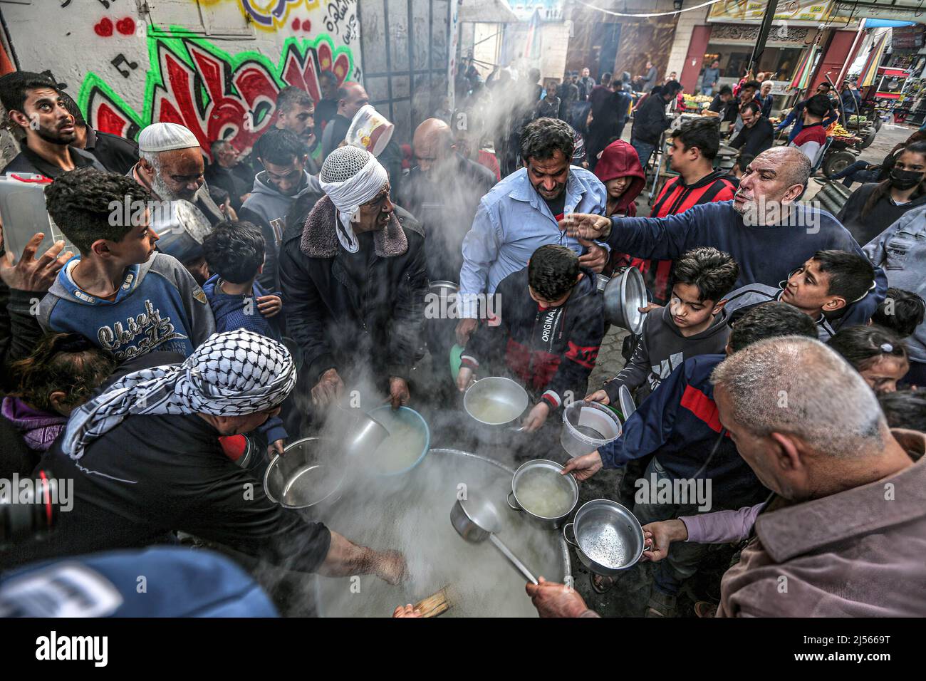 Gaza, Palestina. 20th Apr 2022. I palestinesi ricevono zuppa gratuita durante il Ramadan nel quartiere Shejaiya a Gaza City. I musulmani di tutto il mondo celebrano il mese santo del Ramadan pregando durante la notte e astenendosi dal mangiare e dal bere tra l'alba e il tramonto. Ramadan è il nono mese del calendario islamico e si ritiene che il primo versetto Coranico sia stato rivelato durante le sue ultime dieci notti. (Credit Image: © Yousef Masoud/SOPA Images via ZUMA Press Wire) Foto Stock