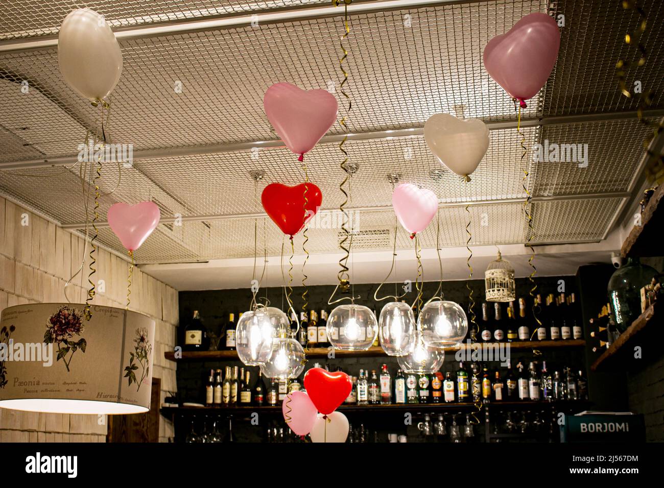 Dnepropetrovsk, Ucraina - 07.24.2021: Bancone bar in un caffè con bottiglie di alcol e decorazioni da palloncini per l'anniversario di matrimonio. Foto Stock