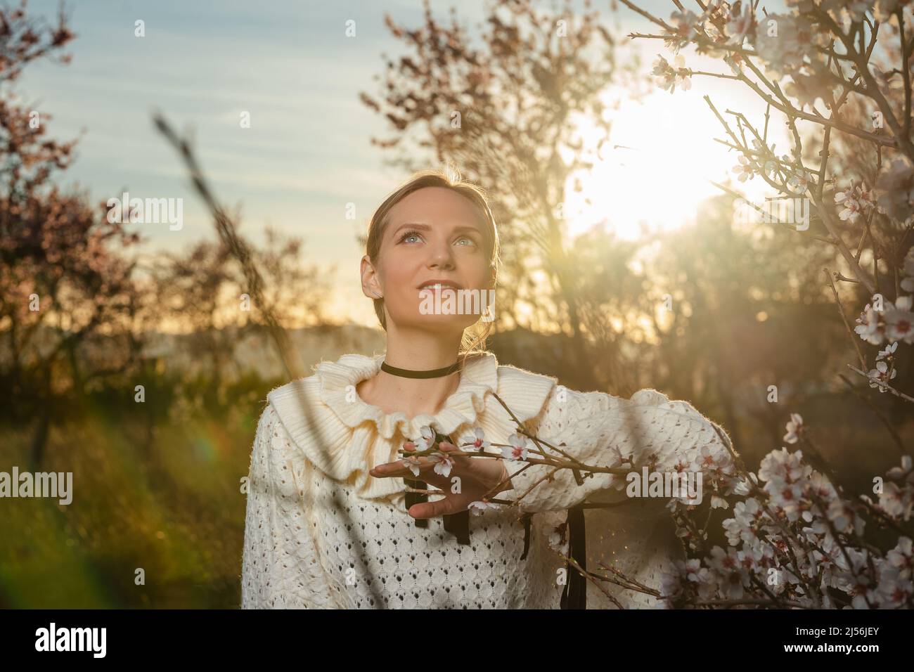 Ragazza sul campo di alberi di mandorle fiorenti Foto Stock