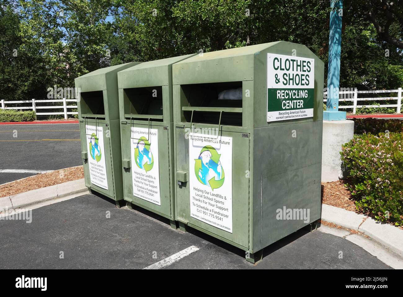Wildomar, CA, Stati Uniti d'America - 20 aprile 2022: Tre bidoni di donazione di vestiti e scarpe in un parcheggio di supermercato. Foto Stock