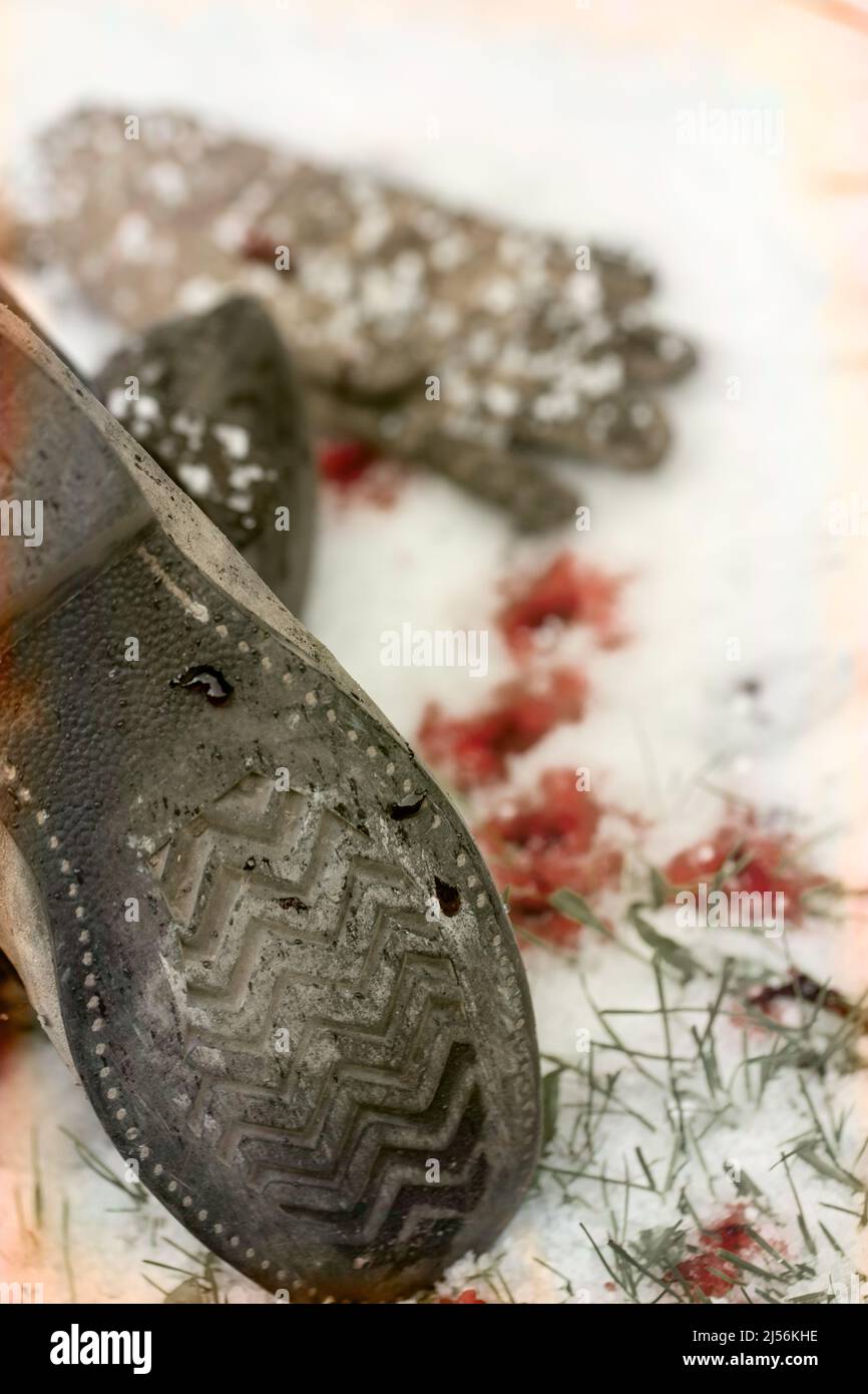 Vecchio stivale, guanto in pelle e macchie di sangue nella neve - un concetto di copertina libro Foto Stock
