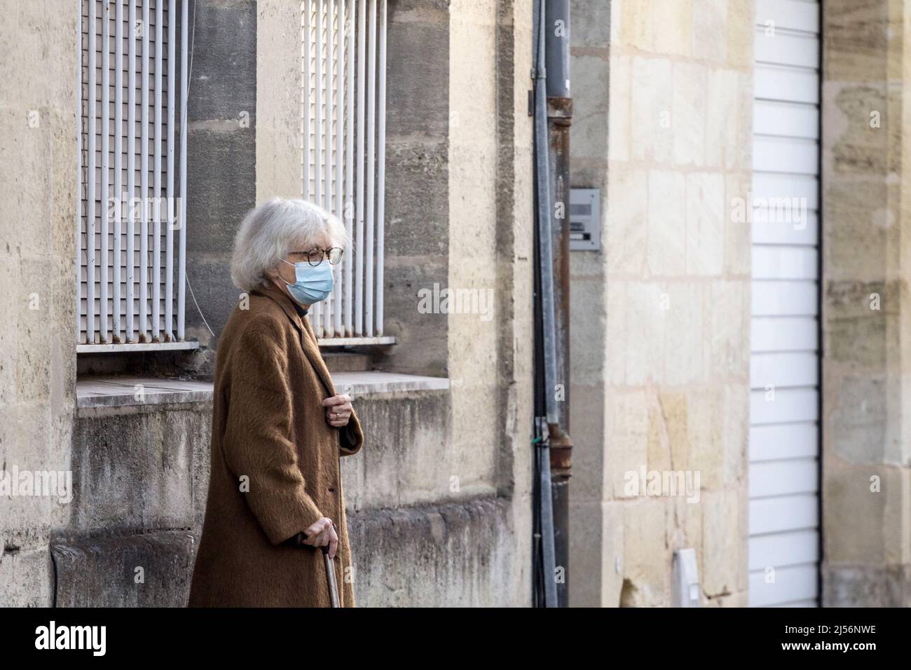 Foto di una donna bianca anziana caucasica, che cammina per le strade di Bordeaux, in via Sainte Catherine, in francia, indossando un volto respiratorio Foto Stock