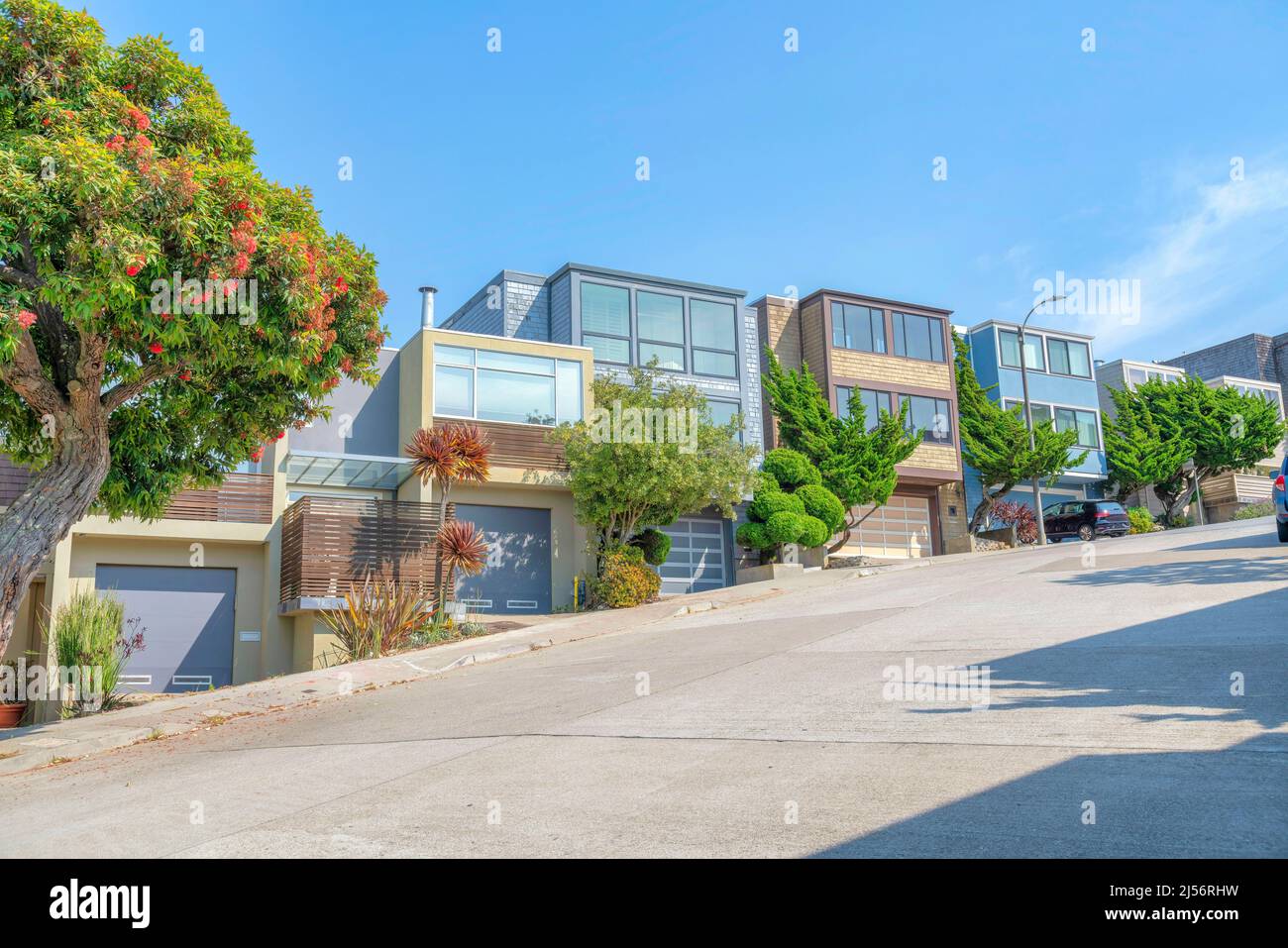 Terra di quartiere sloped a San Francisco, California con le case di scatola complesse. Esterno del quartiere con garage vialetti e alberi vicino al c Foto Stock