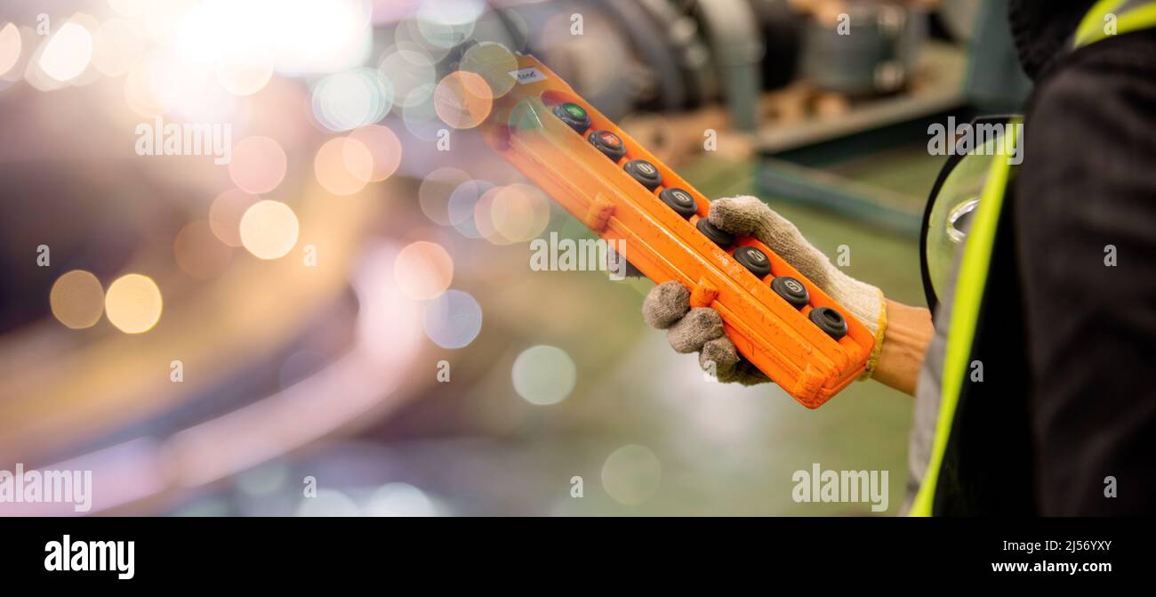 Interruttore di comando a distanza manuale operatore per carroponte in fabbrica, tecnico che controlla l'ascensore nel magazzino industriale di fabbrica Foto Stock