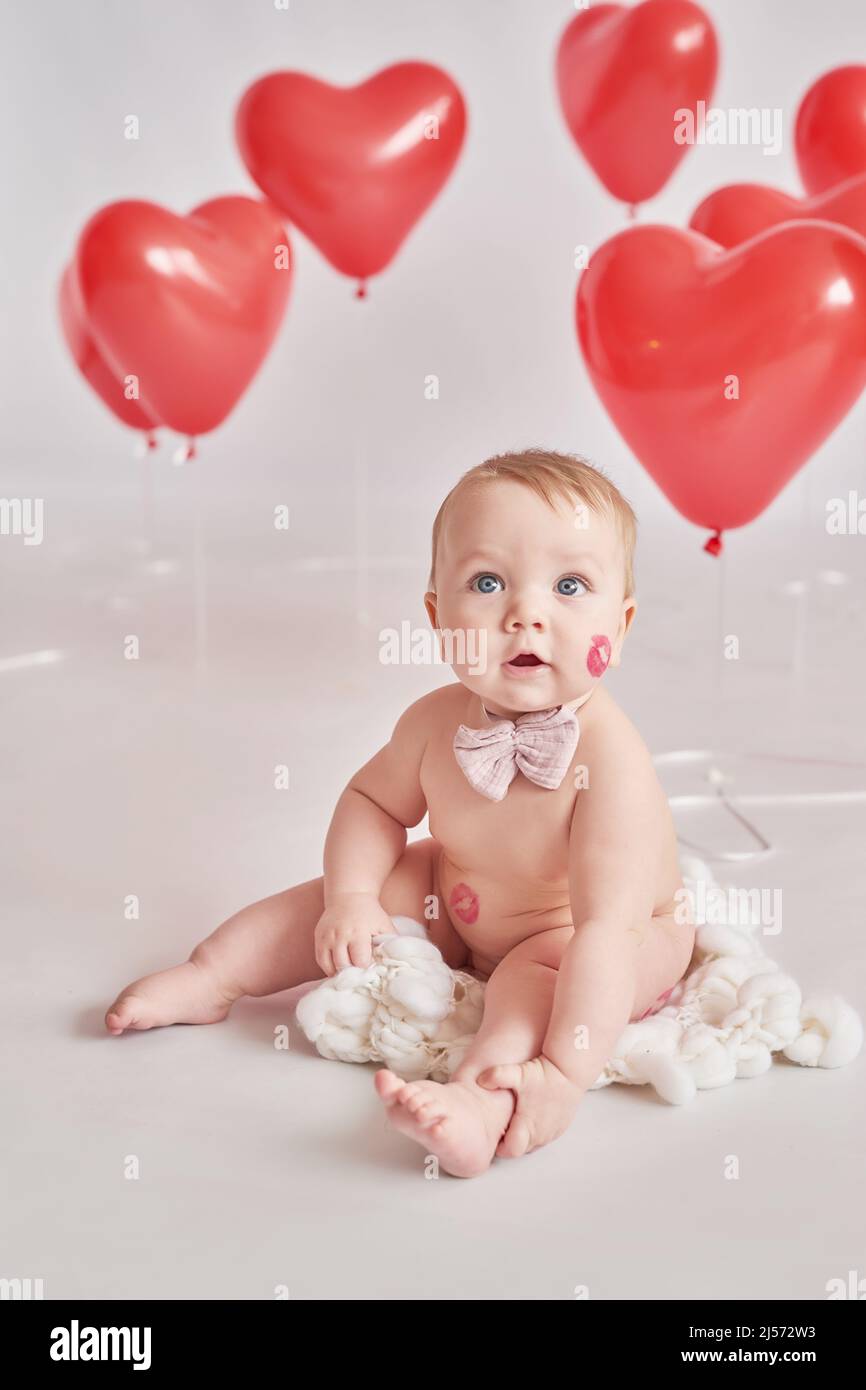 Bambino di San Valentino con bacio sulla guancia. San Valentino. Palle e fiori. Celebrazione. Cartolina del giorno della madre. Giornata internazionale della felicità. Birthda Foto Stock